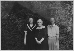 three white women posing in a row in dresses, one younger woman, one older woman, and one middle aged woman