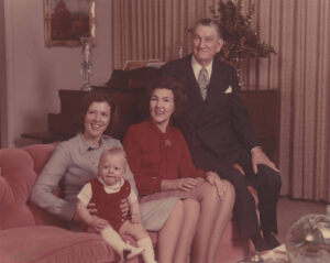 white family on couch in formal clothes with baby
