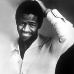 Black man in white shirt and his hand on his head