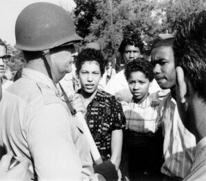 soldier with helmet standing next to group of Black teens
