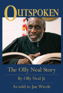 African American man in robes with open book on "Outspoken" book cover