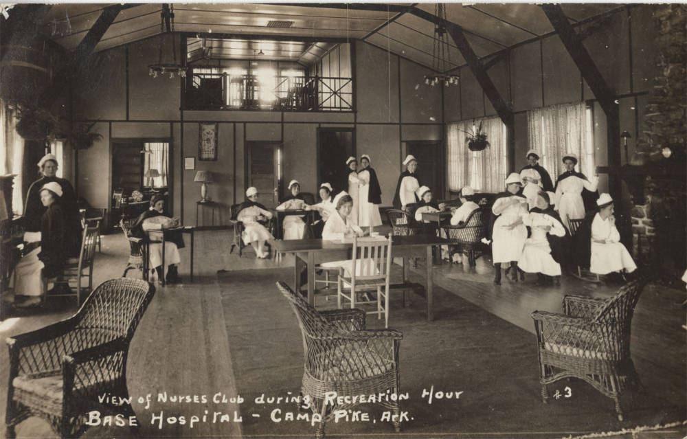 interior with high ceiling and women dressed in white with black capes on couches and chairs 