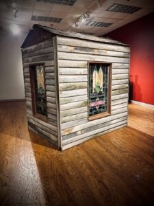 A small simple wooden building with stained glass windows