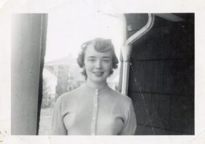 a young white woman with wavy hair in a buttoned sweater
