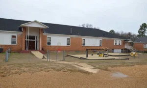 brick and book building with play equipment in front