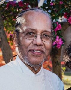 African American man with glasses and light facial hair in white shirt