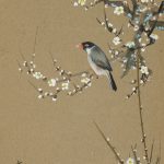 Small bird is perched on the outer branches of a blossoming white cherry tree