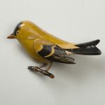 Wooden lacquer pin of a bird on a branch
