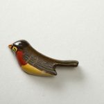 Wooden lacquer pin of a robin perched