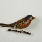 Wooden lacquer pin of a robin on a branch