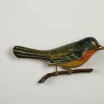 Wooden lacquer pin of a bird on a branch