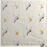 Alternating birds perched on branches on white linen