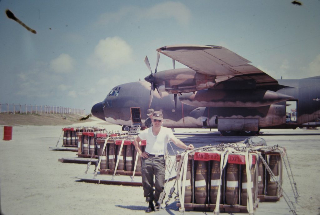Dick Picard standing by pallets of ammunition ready to load on a C-130 bound for Vietnam.