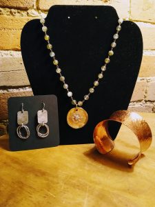 Earrings necklace with round pendant and bracelet on display