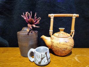 Ceramic cup flower vase and teapot with handle on display
