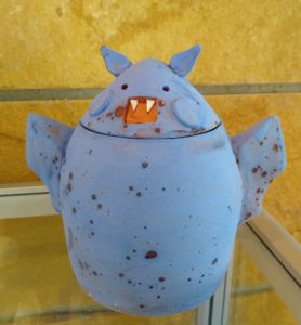 "Bat" ceramic jar on display case
