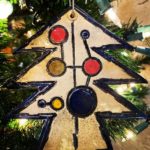 Multicolored Christmas tree ornament hanging on tree