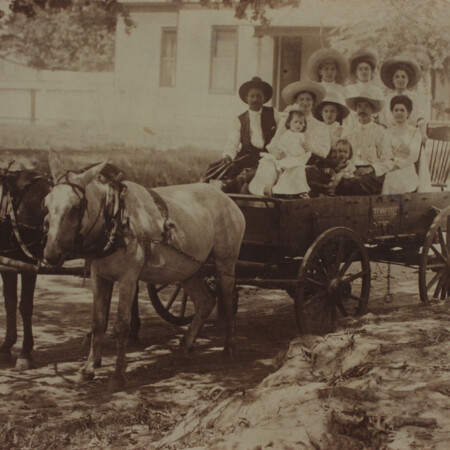 group of people in wagon pulled by horse