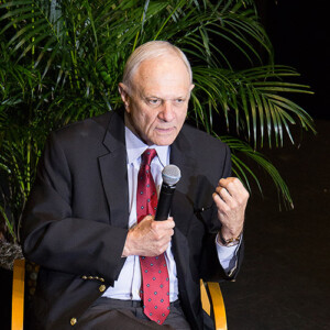 White man speaking into a microphone